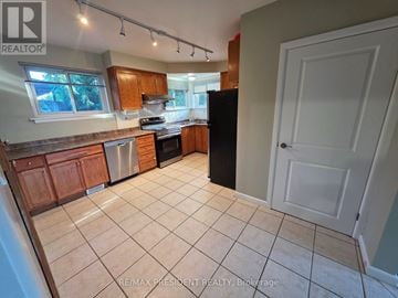 Burlington (Mountainside) apartment for rent - A kitchen with a black refrigerator and brown cabinets.