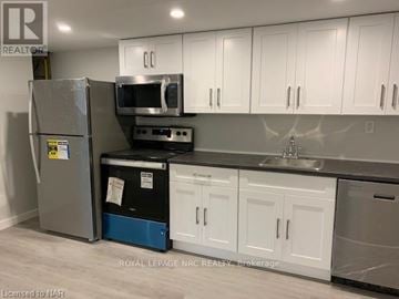 St. Catharines (Bunting/Linwell) apartment for rent - A kitchen with white cabinets and a stainless steel refrigerator.