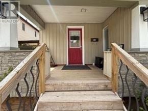 Niagara Falls (Hospital) apartment for rent - A red door is at the end of a wooden staircase.