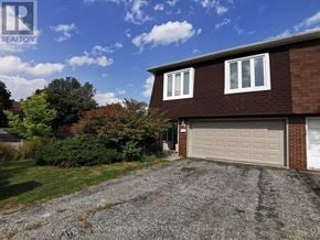 Toronto (Hillcrest Village) apartment for rent - A brown house with a white garage door is for sale.