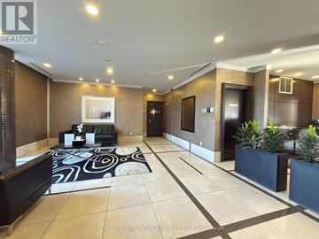Markham (Unionville) condo for rent - A spacious living room with a black and white patterned rug, a sofa set, and a potted plant.