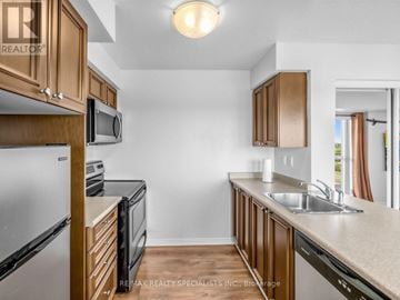 Brampton (Queen Street Corridor) condo for rent - A kitchen with wooden cabinets and a white refrigerator.
