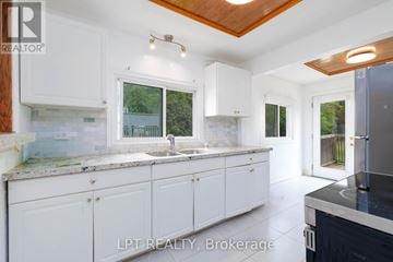 Georgina (Historic Lakeshore Communities) apartment for rent - A kitchen with white cabinets and a wooden ceiling.