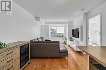 Richmond Hill (Langstaff) condo for rent - A modern living room with a brown sofa and a television.