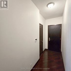 Mississauga (City Centre) condo for rent - A hallway with a door on the right and a light switch on the wall.