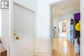 Toronto (Little Portugal) apartment for rent - A white door with a gold handle is in a room with a wooden floor.
