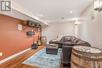Ottawa apartment for rent - A living room with a leather couch and a guitar on the wall.