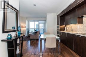 Toronto (Willowdale East) condo for rent - A modern kitchen with dark wood cabinets and a white countertop.