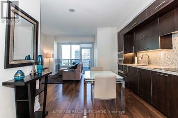 Toronto (Willowdale East) condo for rent - A modern kitchen with dark wood cabinets and a white countertop.