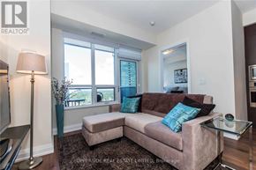 Toronto (Willowdale East) condo for rent - A living room with a couch, a lamp, and a glass table.
