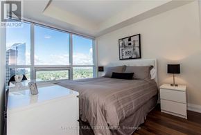 Toronto (Willowdale East) condo for rent - A bedroom with a large bed and a view of the city.