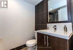 Toronto (Willowdale East) condo for rent - A bathroom with a toilet, sink and mirror.