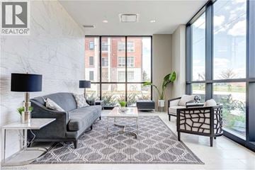Kitchener condo for rent - A living room with a grey couch and a black floor lamp.