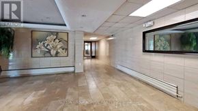 Toronto (Westminster-Branson) condo for rent - A hallway with a tiled floor and a wall with a framed picture of flowers.