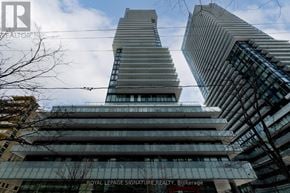 Toronto (Mount Pleasant West) condo for rent - A tall building with a glass facade stands in front of another skyscraper.