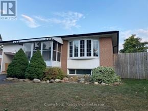 Toronto (Woburn) apartment for rent - A house with a white fence and a small garden in front.