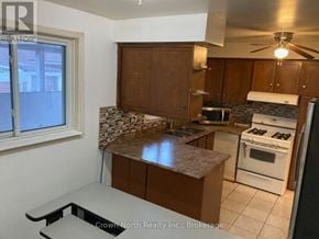 Toronto (Woburn) apartment for rent - A kitchen with white appliances and brown cabinets.