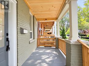 Toronto (Greenwood-Coxwell) apartment for rent - A porch with a wooden railing and a grey door.