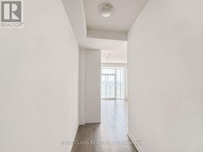Vaughan (Vaughan Corporate Centre) condo for rent - A white hallway with a door on the left and a window on the right.