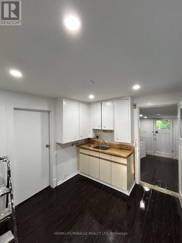 Brampton (Downtown Brampton) apartment for rent - A kitchen with white cabinets and a wooden island.
