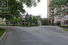 Mississauga (Hurontario) condo for rent - A street view of a residential area with apartment buildings and trees.