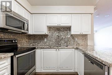 Mississauga (Hurontario) condo for rent - A kitchen with white cabinets and granite countertops.