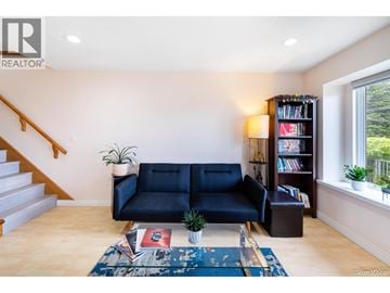Burnaby apartment for rent - A living room with a blue couch and a bookshelf.