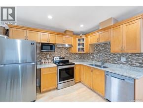 Burnaby apartment for rent - A kitchen with wooden cabinets and a stone backsplash.