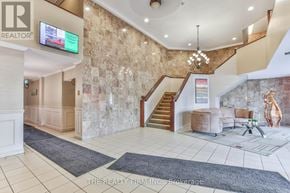 London East (East K) condo for rent - A reception area with a staircase and a flat screen TV.