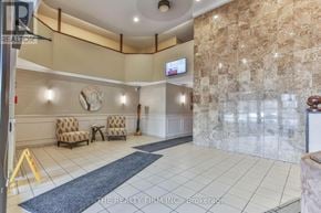 London East (East K) condo for rent - A reception area with a stone wall and a flat screen TV.