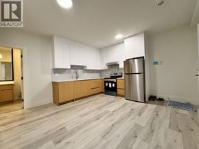 Burnaby apartment for rent - A kitchen with wooden floors and white cabinets.