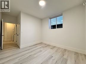 Burnaby apartment for rent - A spacious room with a window and a door leading to another room.