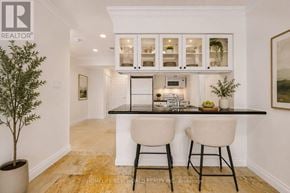 Toronto (Bay Street Corridor) condo for rent - A well-lit kitchen with white cabinets and a black countertop.