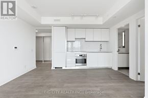 Toronto (Thorncliffe Park) condo for rent - A white kitchen with a refrigerator, oven, and cabinets.