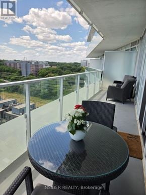Toronto (Edenbridge-Humber Valley) condo for rent - A glass table with a vase of flowers on it sits on a balcony with a view of the city.