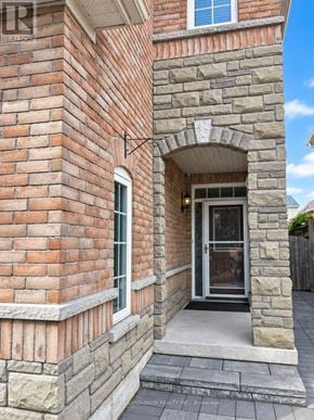 Markham (Berczy) apartment for rent - A house with a stone archway entrance and a brick wall.