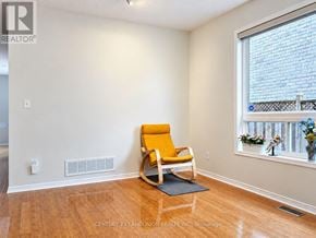Markham (Berczy) apartment for rent - A room with a yellow chair and a window with a view of a brick building.