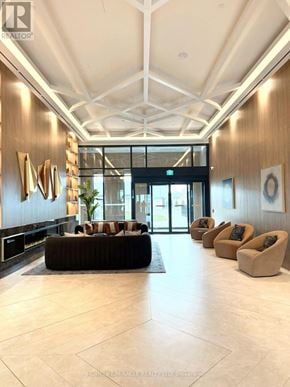 Vaughan (Vaughan Corporate Centre) condo for rent - A modern lobby with a large brown couch and a glass door.