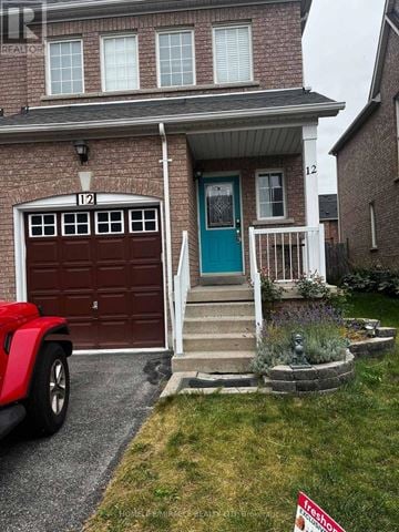 Whitby (Taunton North) townhouse for rent - A red car is parked in front of a house with a garage door that is numbered 12.