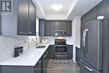 Vaughan (Maple) townhouse for rent - A kitchen with black cabinets and a white countertop.