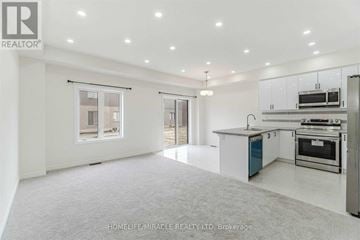 Brantford townhouse for rent - A spacious kitchen with white cabinets and stainless steel appliances.