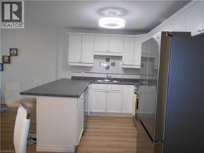 Port Dover condo for rent - A kitchen with white cabinets and a black countertop.