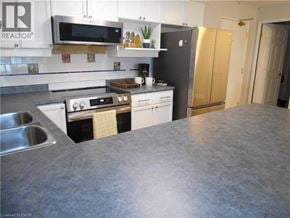 Port Dover condo for rent - A kitchen with a stove top oven and a refrigerator.