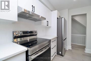 Ottawa triplex for rent - A modern kitchen with white cabinets and stainless steel appliances.