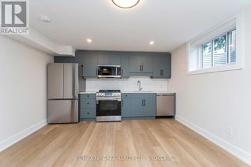 St. Catharines (Carlton/Bunting) apartment for rent - A kitchen with a refrigerator, oven, microwave, and cabinetry.