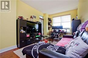 Markham (Unionville) condo for rent - A living room with a black couch and a TV on a stand.