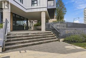Brampton (Northwest Brampton) condo for rent - A modern house with a glass door and a sign that reads "180 Veterans Drive".