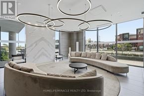 Brampton (Northwest Brampton) condo for rent - A modern living room with a large circular light fixture and a view of the city.
