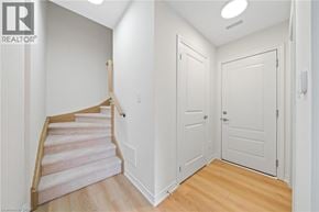 Hamilton townhouse for rent - A hallway with a staircase and two doors.