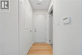 Hamilton townhouse for rent - A hallway with a door and a wall-mounted thermostat.